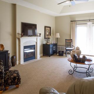 A cozy living room featuring a fireplace, television, sofa, and coffee table.