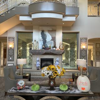 A beautifully decorated living room featuring autumn-themed decor with pumpkins and sunflowers.