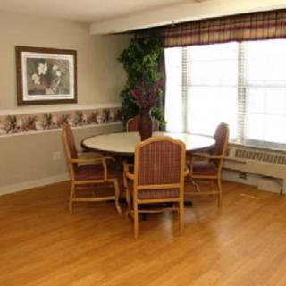 A cozy dining area with a round table and four chairs, accented by a large window.