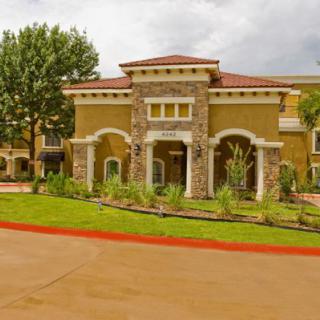 A stylish building with a landscaped entrance and surrounding greenery.