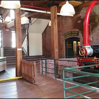 The interior of a historic industrial facility featuring exposed brick walls and vintage machinery.