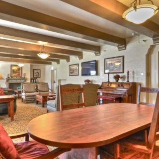 A cozy lounge area with wooden furniture and ceiling beams.