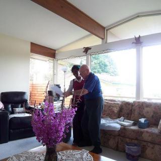 Two people interacting in a cozy living room with natural light.