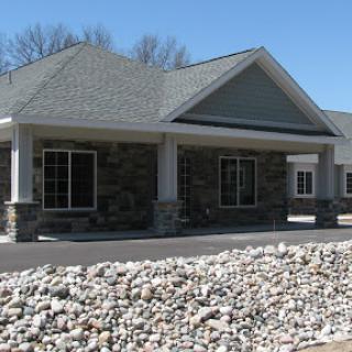 A modern building featuring a stone facade and clear blue sky.