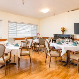 A cozy dining area set for a meal, featuring elegantly arranged tables and comfortable chairs.