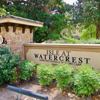 Entrance sign for Isle at Watercrest, surrounded by lush greenery.