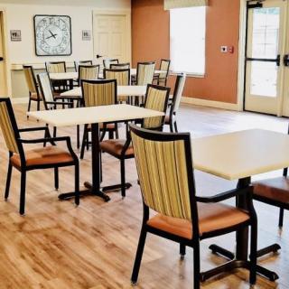 An empty dining room with neatly arranged tables and chairs.
