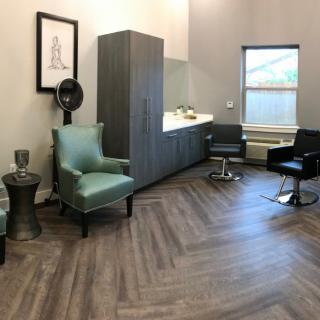 A modern salon interior featuring stylish chairs and wooden flooring.
