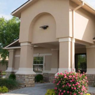 A beautifully designed residential building with elegant columns and vibrant landscaping.