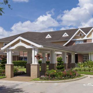 A well-maintained residential building with a covered entrance and landscaped surroundings.