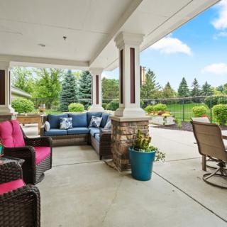 A cozy outdoor patio with comfortable seating and a beautiful garden view.