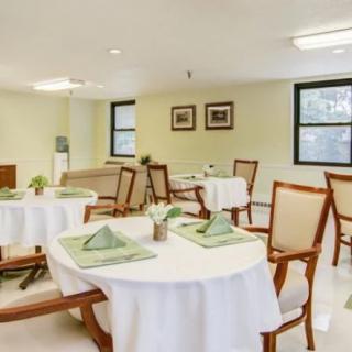 A neatly arranged dining room with tables and chairs set for a meal.