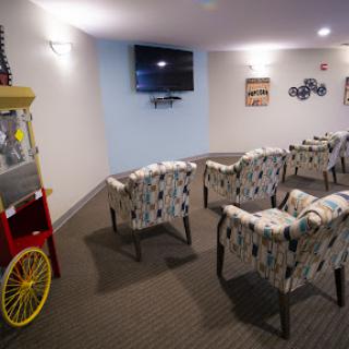 A cozy lounge area with comfortable seating, a TV for entertainment, and a vintage popcorn machine.