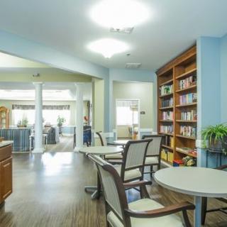 A modern library interior featuring bookshelves, tables, and chairs.