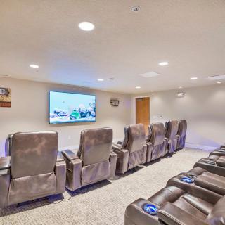 A cozy home theater with multiple recliner chairs and a large projector screen.