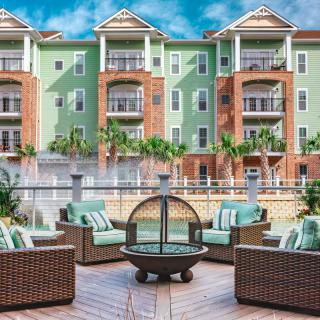 Modern apartment complex with outdoor seating and fire pit.
