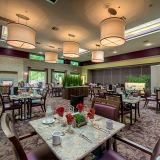 A modern and elegant dining room with neatly set tables and ambient lighting.