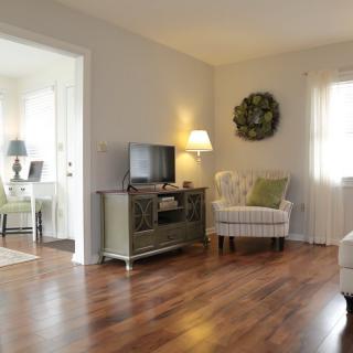 A cozy living room featuring hardwood floors, a comfortable chair, and a television.