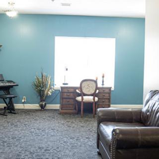 A cozy living space featuring a workspace with a desk and chair, complemented by a green accent wall.