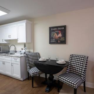 A cozy kitchen area with checkered chairs and a small dining table.