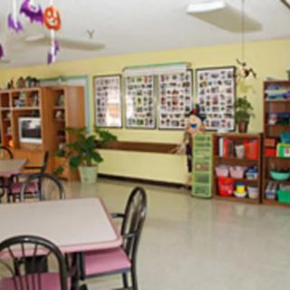A colorful and inviting classroom with tables, chairs, and various educational decorations.