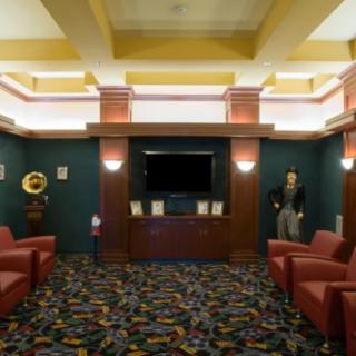A view of a lobby with comfortable seating, a television, and decorative lighting.