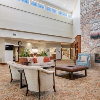 A spacious, modern lobby featuring a seating area with comfortable chairs and a fireplace.