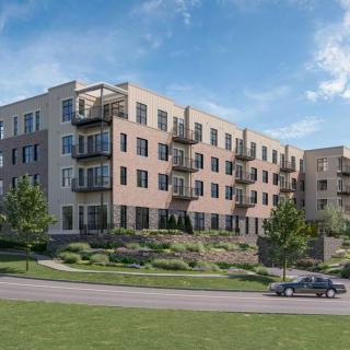 A modern apartment complex with balconies, surrounded by well-maintained landscaping.