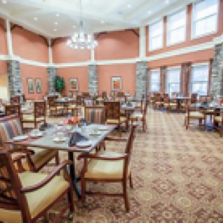 A spacious dining room with elegantly set tables and comfortable seating.