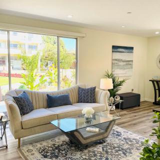 A bright and modern living room with a glass coffee table, comfortable sofa, and stylish decor.