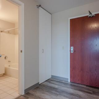 A modern apartment entrance with a view into the bathroom.