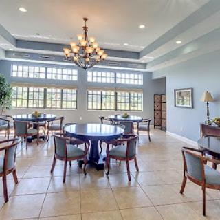 A spacious and elegantly designed dining area featuring modern furnishings and abundant natural light.