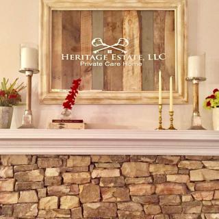 A rustic mantel decorated with candles, stone accents, and a framed sign.