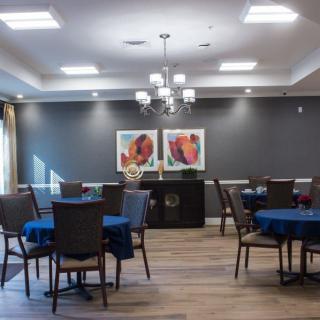 A modern dining area with tables, chairs, and decorative artwork on the walls.