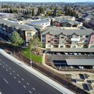Aerial view of a residential apartment complex with adjacent roads and parking areas.