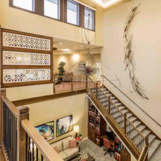 A modern loft-style interior featuring a spacious staircase and contemporary artwork.