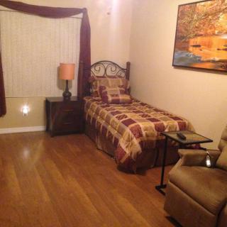 A cozy bedroom with a single bed and comfortable seating.