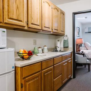 A cozy kitchen area with wooden cabinets and a fruit bowl on the countertop.