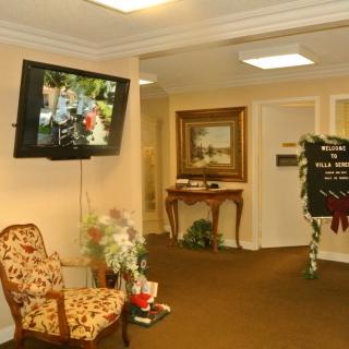 A cozy lobby area with a floral chair, television, and elegant decor.