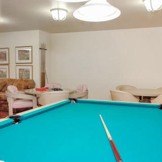 A cozy billiard room featuring a pool table and comfortable seating.