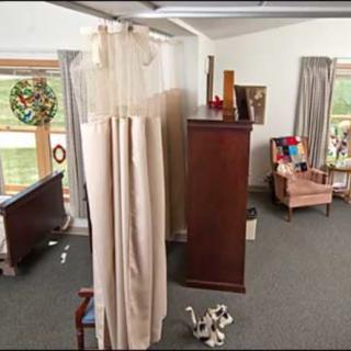A cozy living room with a sofa, chest of drawers, and decorative items.