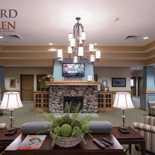 A well-decorated lobby with a central chandelier, stone fireplace, and comfortable seating.