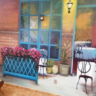 A charming cafe with colorful decor, featuring outdoor seating and vibrant flowers.