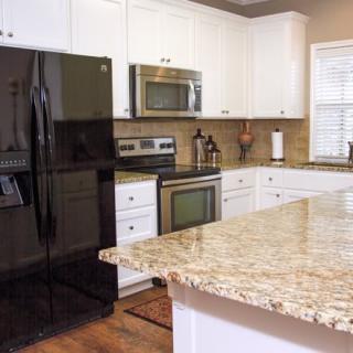 A modern kitchen with granite countertops and stainless steel appliances.
