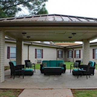 An outdoor patio with comfortable seating under a gazebo.