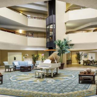 Spacious hotel lobby with modern decor and central atrium.