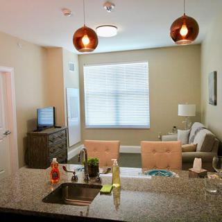 A modern apartment interior showcasing a kitchen area with an island and a cozy living room.