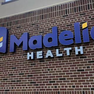 Signage for Madelia Health displayed prominently on a brick wall.