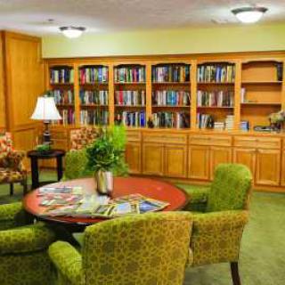 A cozy library with bookshelves and a seating area.