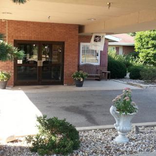 The welcoming entrance of a building, adorned with potted plants and a well-kept outdoor space.